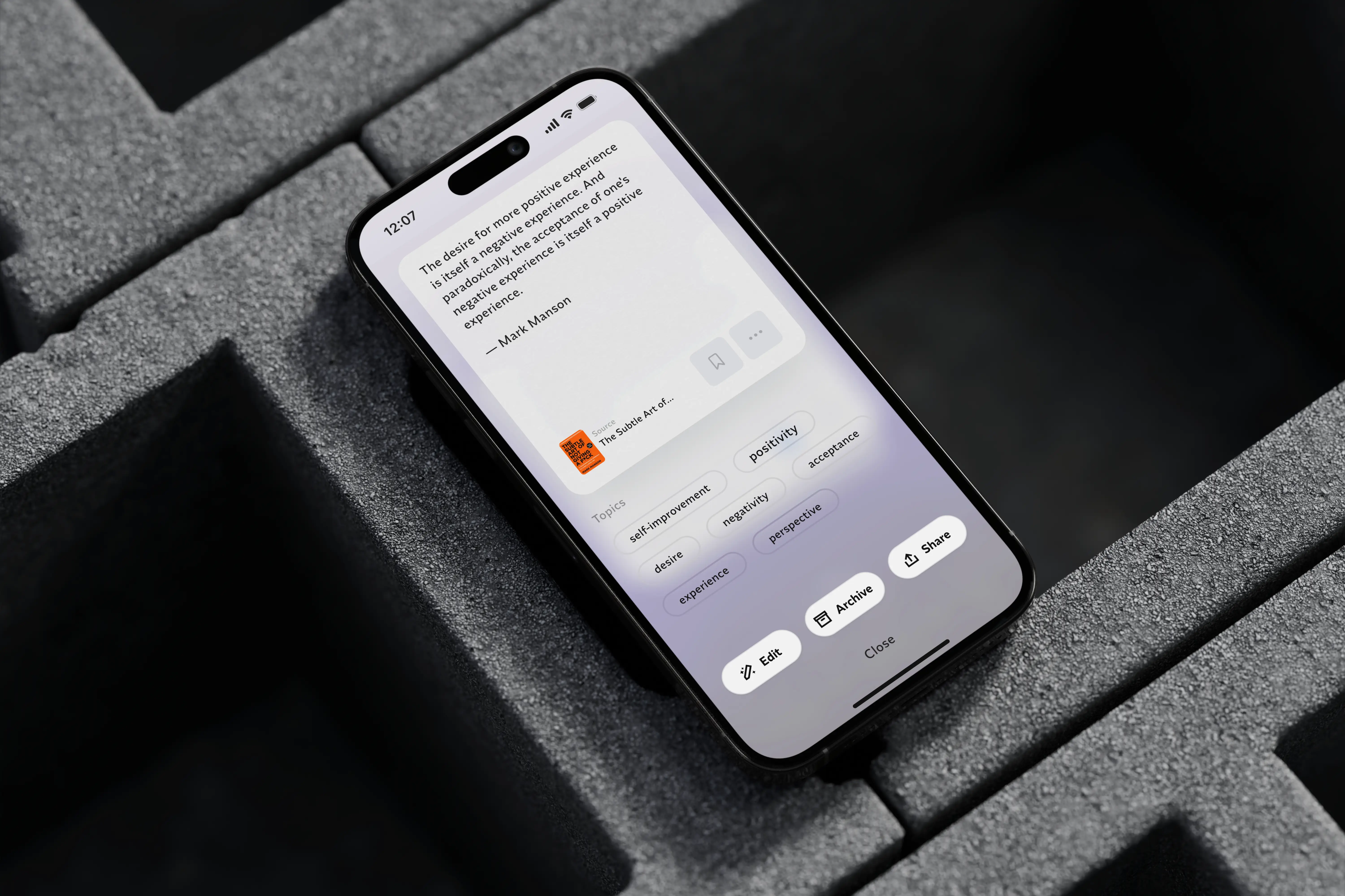 iPhone 16 displaying the Napkin app with a quote by Mark Manson, topic tags and edit, archive, share action options.