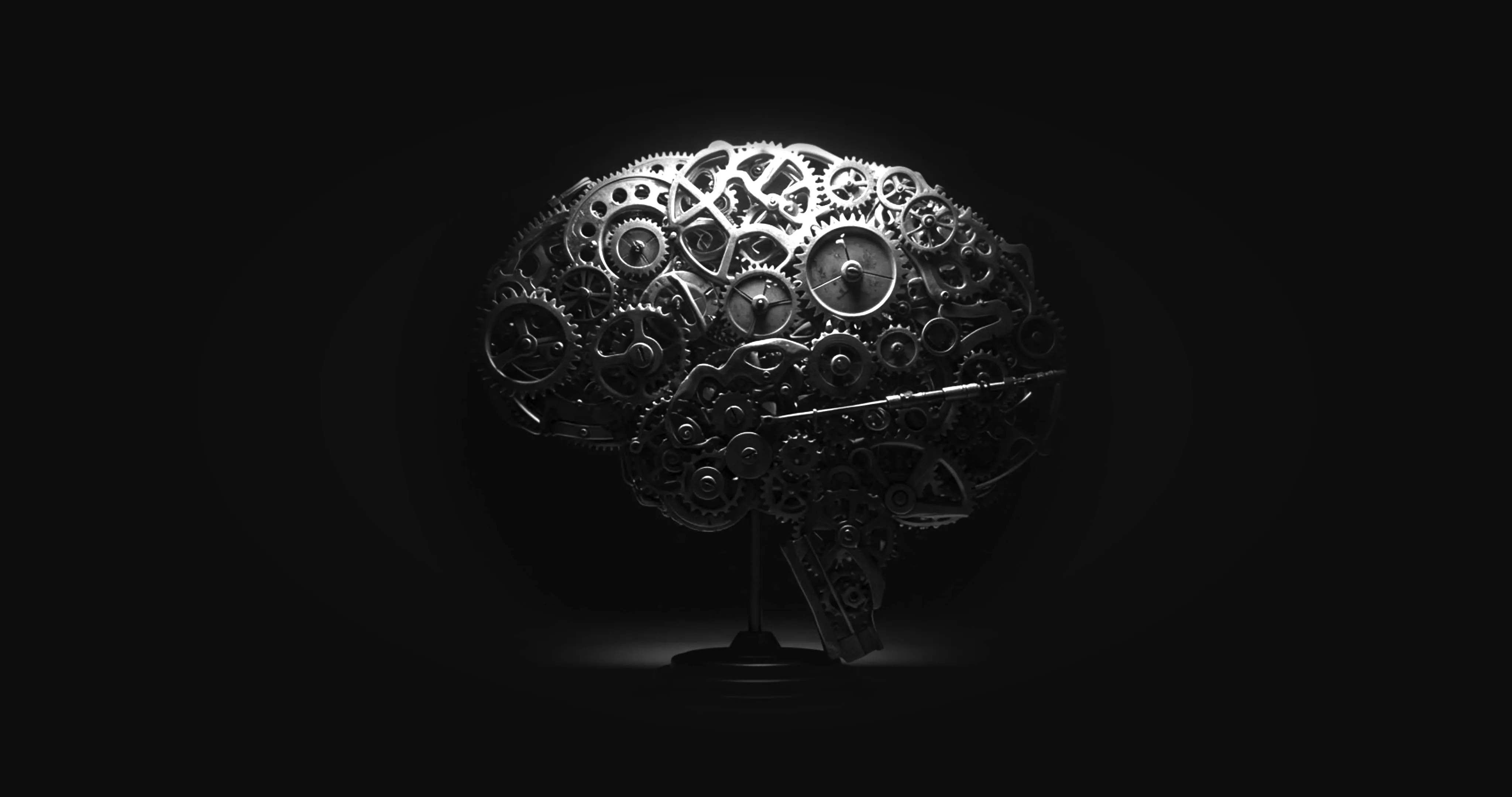 A mechanical brain sculpture composed of interconnected gears and cogs on a stand.